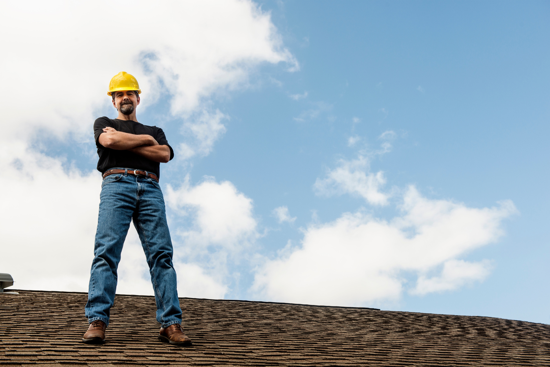 American Roofing Contractor Standing on Home Roof